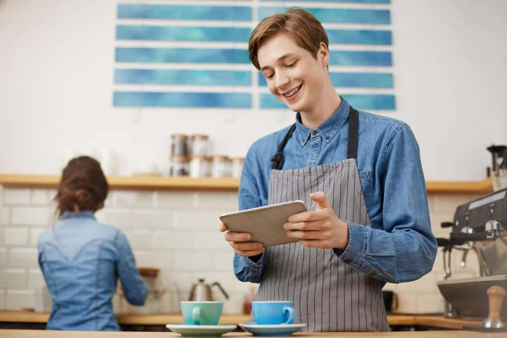blog 22654a607032 male cashier taking orders using tab bright coffee shop min